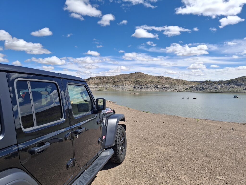 Jeep parked near Elephant Butte Lake with scenic desert hills in the background